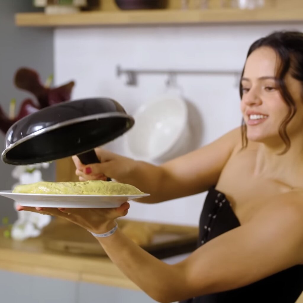 Finalmente, da la vuelta a la tortilla con un plato y la sirve con pan.