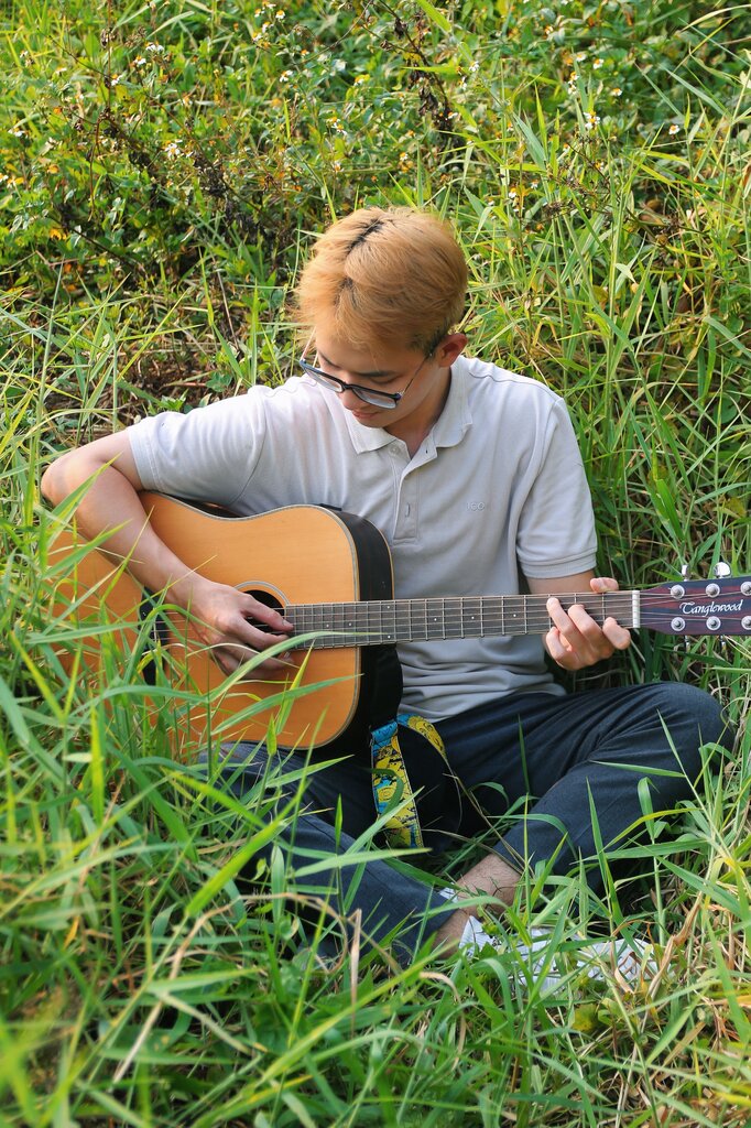 Kevin practices __________ the guitar before his music lesson.