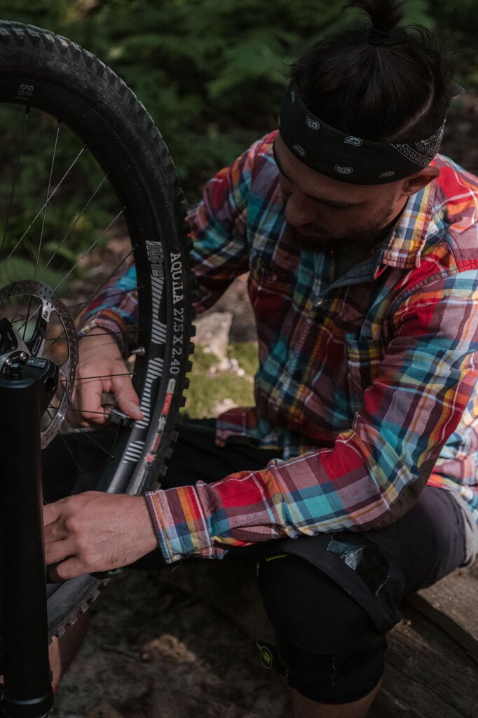 Dad is busy __________ the broken bicycle in the garage.