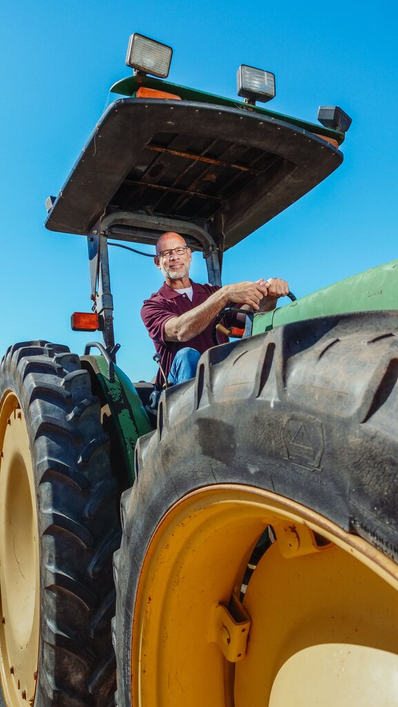 Who grows vegetables and fruits and works with animals such as cows, pigs, chickens?
