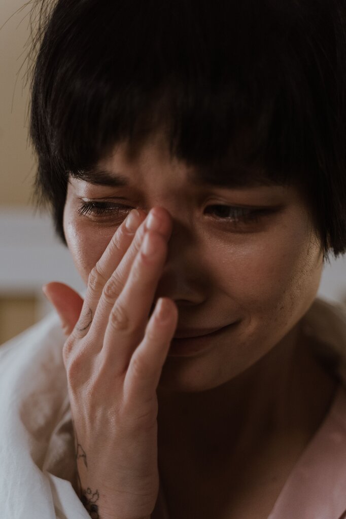 A person with a frown and teary eyes is in the image. Which feeling fits best?