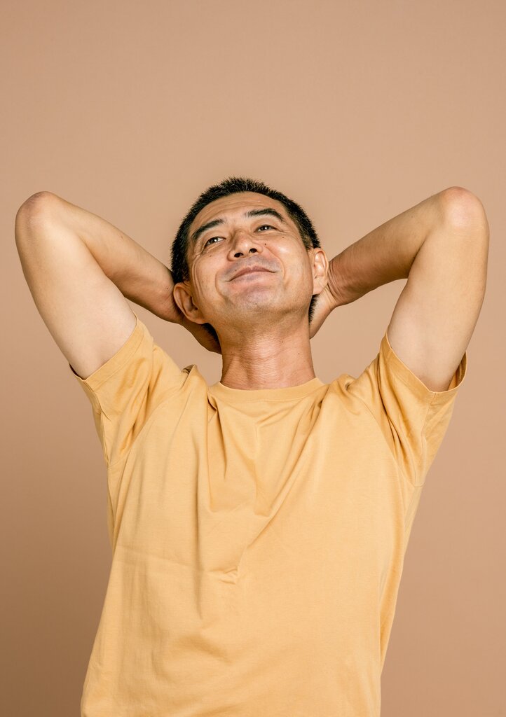 A person sitting with a soft smile and relaxed posture. Which feeling is this?